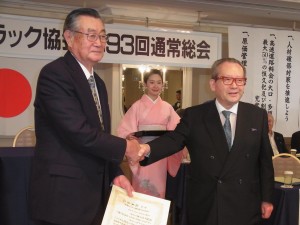 握手する星野前会長（左）と坂本新会長